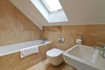 a bathroom with a toilet and a sink and a skylight at 50m FROM THE BEACH, dogs welcome in St Merryn