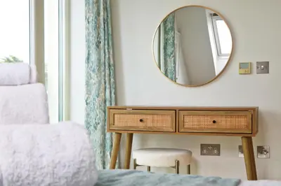 a bedroom with a dressing table and a mirror at 50m FROM THE BEACH, dogs welcome in St Merryn