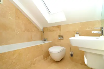 a bathroom with a toilet and a sink and a skylight at 50m FROM THE BEACH, dogs welcome in St Merryn