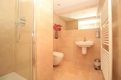 a bathroom with a shower and a toilet and a sink at BEACHSIDE SPACIOUS apartment, private garden in St Merryn