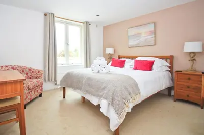 a bedroom with a bed with two teddy bears on it at BEACHSIDE SPACIOUS apartment, private garden in St Merryn