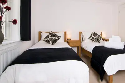 a bedroom with two beds and a window at BY THE BEACH, spacious apartment in St Merryn