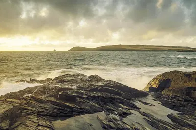 a view of the ocean with rocks in the water at BY THE BEACH, spacious apartment in St Merryn