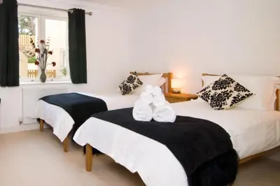 a bedroom with two beds with white shoes on them at BY THE BEACH, spacious apartment in St Merryn