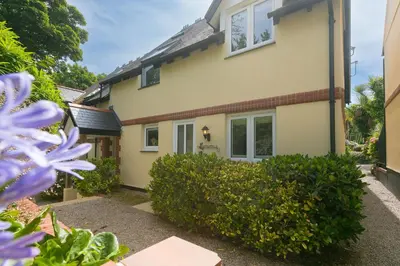a house with purple flowers in front of it at Lamorna in St Ives