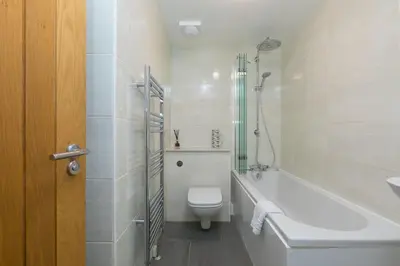a bathroom with a toilet and a tub and a sink at Lamorna in St Ives