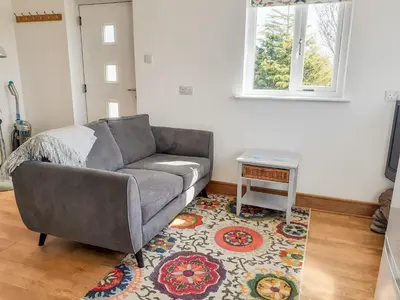 a living room with a couch and a table at Valley View in St Austell