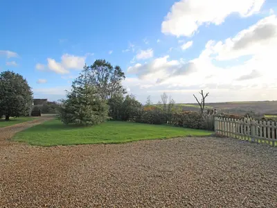 a garden with a wooden fence and grass at Valley View in St Austell