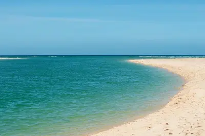 a beach with blue water and a sandy shore at Hillside Studio in Penzance