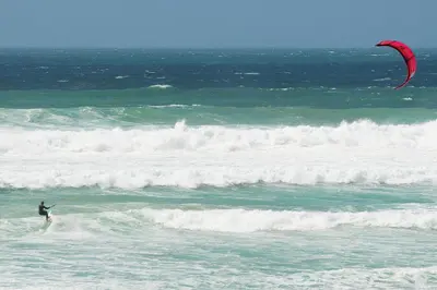 a man kite surfing on the waves in the ocean at Hillside Studio in Penzance