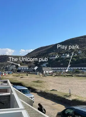 a dog sitting on the balcony of a play park at Sunsets In Porthtowan, Beachfront apartment in Porthtowan