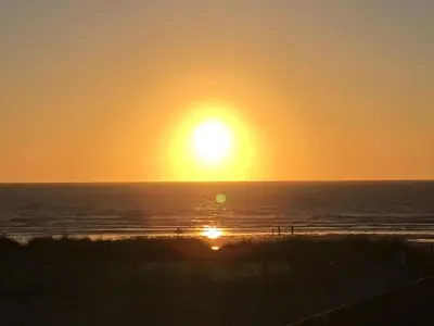 a sunset on the beach with the sun setting at Sunsets In Porthtowan, Beachfront apartment in Porthtowan