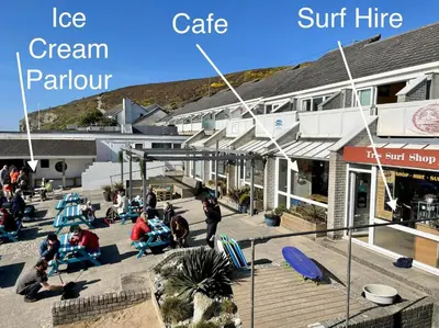 a group of people sitting on chairs outside a building at Sunsets In Porthtowan, Beachfront apartment in Porthtowan