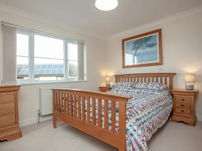 a bedroom with a bed and two windows at The White House in Poundstock