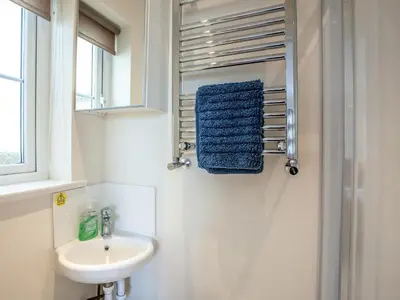a white bathroom with a sink and a mirror at The White House in Poundstock