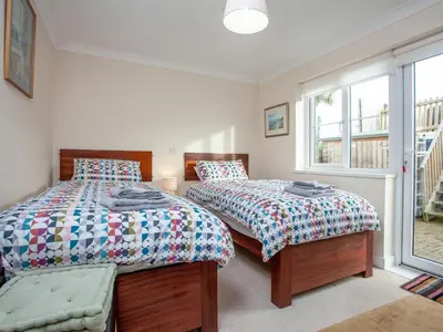 a bedroom with two beds and a window at The White House in Poundstock