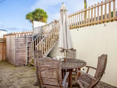 a table with an umbrella and chairs on a patio at The White House in Poundstock