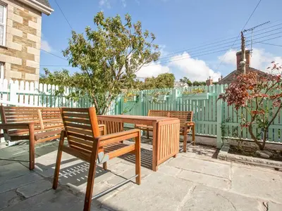 three wooden benches sitting next to a fence at 21 British Road in St. Agnes