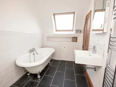 a bathroom with a tub and a sink at 21 British Road in St. Agnes