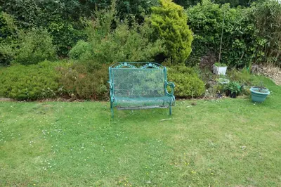 a green bench sitting in the grass in a yard at Kimberley Lane Static, Cornwall in Gwennap