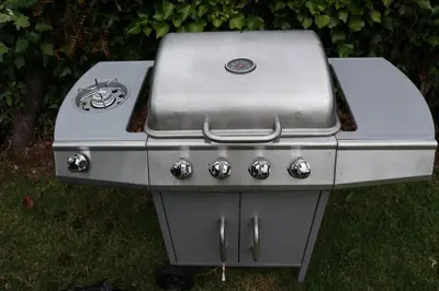 a gas grill sitting on the grass in a yard at Kimberley Lane Static, Cornwall in Gwennap
