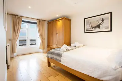 a bedroom with a bed and a large window at The Old Bakery in Falmouth