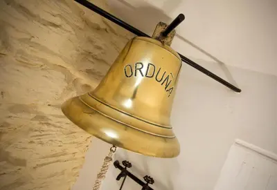 an old church bell hanging on a wall at The Old Bakery in Falmouth