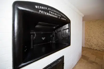 a wall mounted oven with a sign on the wall at The Old Bakery in Falmouth