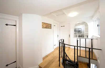 a hallway with white walls and a staircase in a house at The Old Bakery in Falmouth
