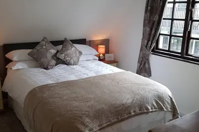 a bedroom with a large bed with pillows at 20 Tudor Court 
