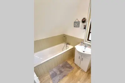 a bathroom with a tub and a sink at 20 Tudor Court 