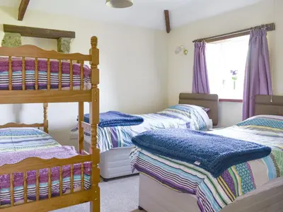 a bedroom with two bunk beds and a window at The Owl's Roost - Uk12087 in Saint Endellion
