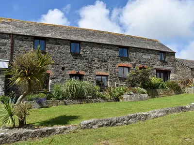 an old stone house with a garden in front of it at Stable Cottage - Uk12088 in Saint Endellion