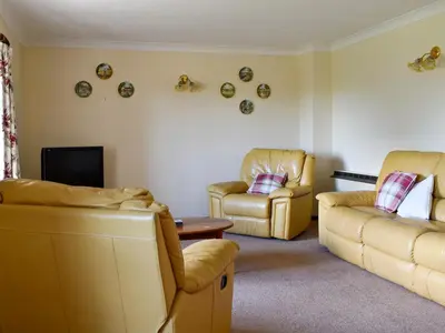 a living room with two chairs and a couch and a tv at Stable Cottage - Uk12088 in Saint Endellion
