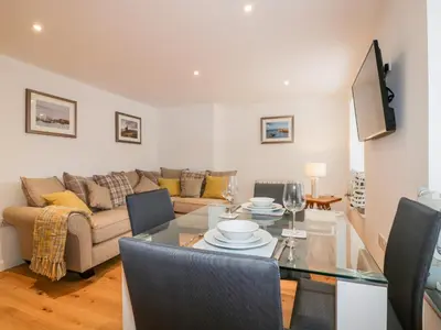 a living room with a table and a couch at Midships in St Austell