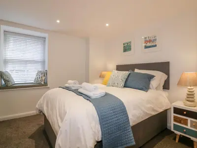 a bedroom with a bed with towels on it at Midships in St Austell