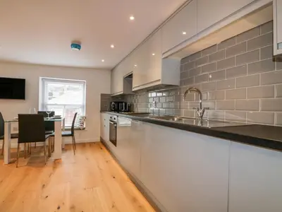 a kitchen with a sink and a table in it at The Crows Nest in St Austell
