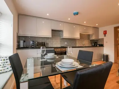 a dining room with a glass table and chairs at The Crows Nest in St Austell
