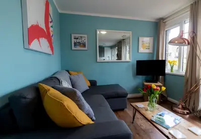a blue living room with a couch and a table at Ocean Cottage in Uny Lelant