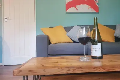 a bottle of wine and a glass on a coffee table at Ocean Cottage in Uny Lelant