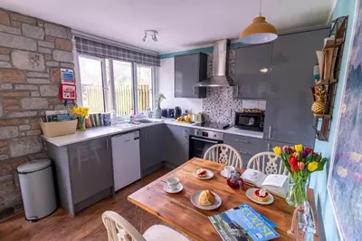 a kitchen with a wooden table and a table and chairs at Ocean Cottage in Uny Lelant