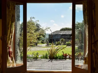 an open window with a view of a barn at Round House - Uk12083 in Saint Endellion