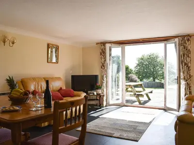 a living room with a couch and a table at Swallows Nest - Uk12085 in Saint Endellion