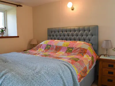 a bedroom with a bed with a quilt on it at Swallows Nest - Uk12085 in Saint Endellion