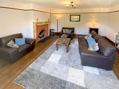 a living room with two leather couches and a fireplace at Penfound Country Cottage in Poundstock