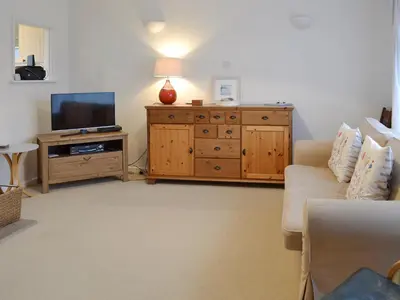 a living room with a couch and a television at Chynoweth in Saint Keverne