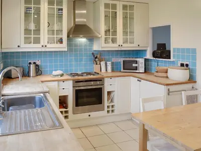 a kitchen with white cabinets and a sink at Chynoweth in Saint Keverne