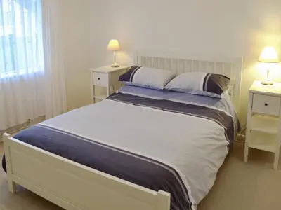 a bedroom with a large white bed with two night stands at Chynoweth in Saint Keverne