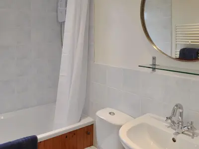 a bathroom with a toilet and a sink and a mirror at Chynoweth in Saint Keverne