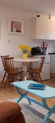 a kitchen with a table and chairs and a table at Woodland Retreat in Uny Lelant